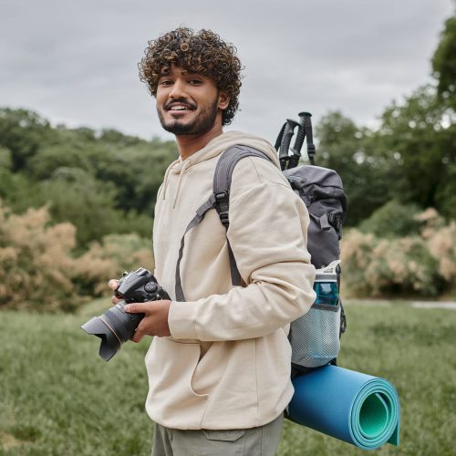 indian-backpacker-smiling-and-holding-digital-came-ZNM4S4V.jpg